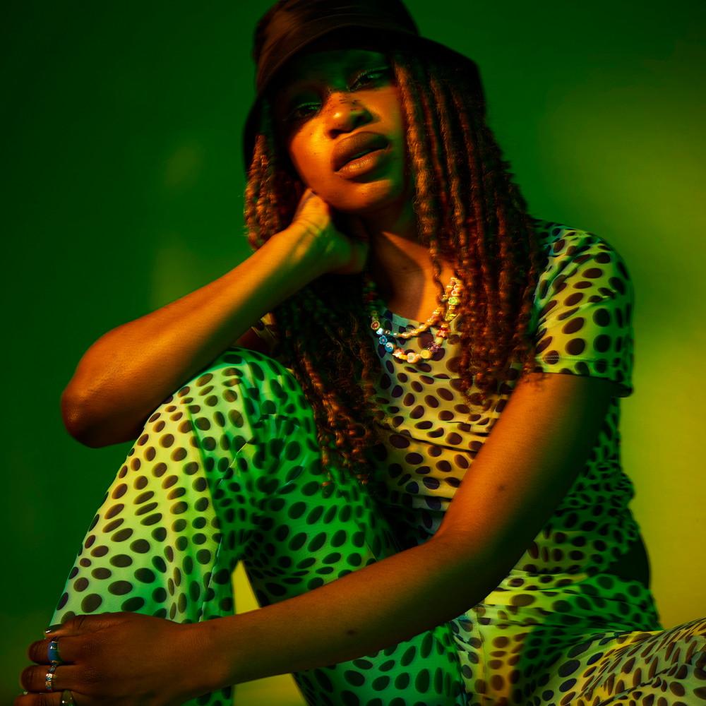 Model wears green mesh printed two piece, paired with a bucket hat