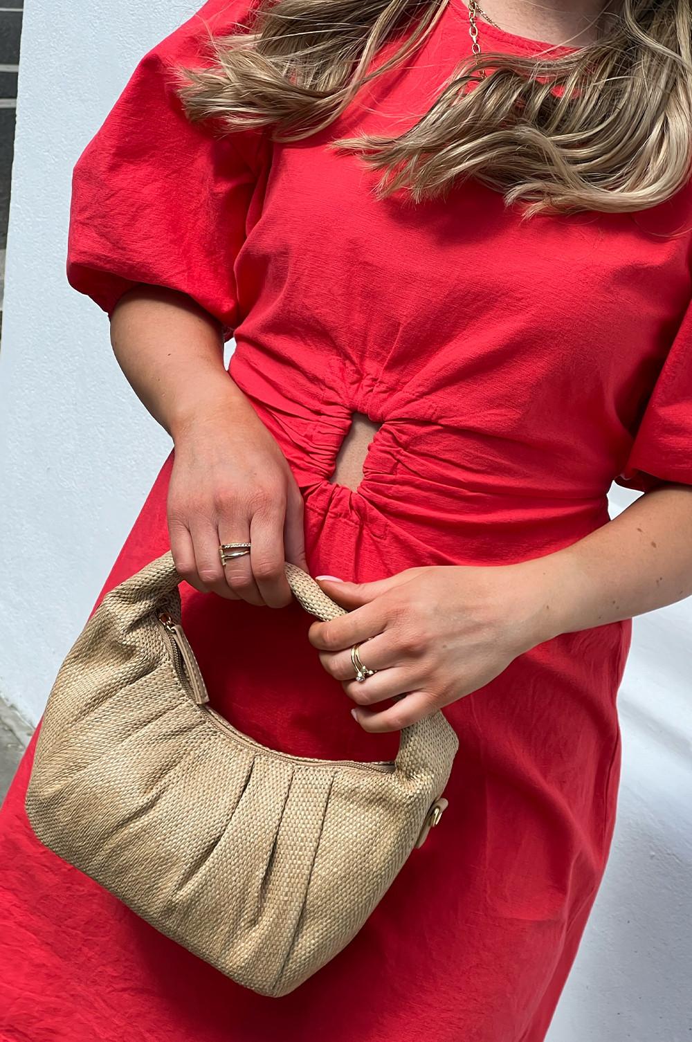 Femme portant une robe rouge et un sac croissant