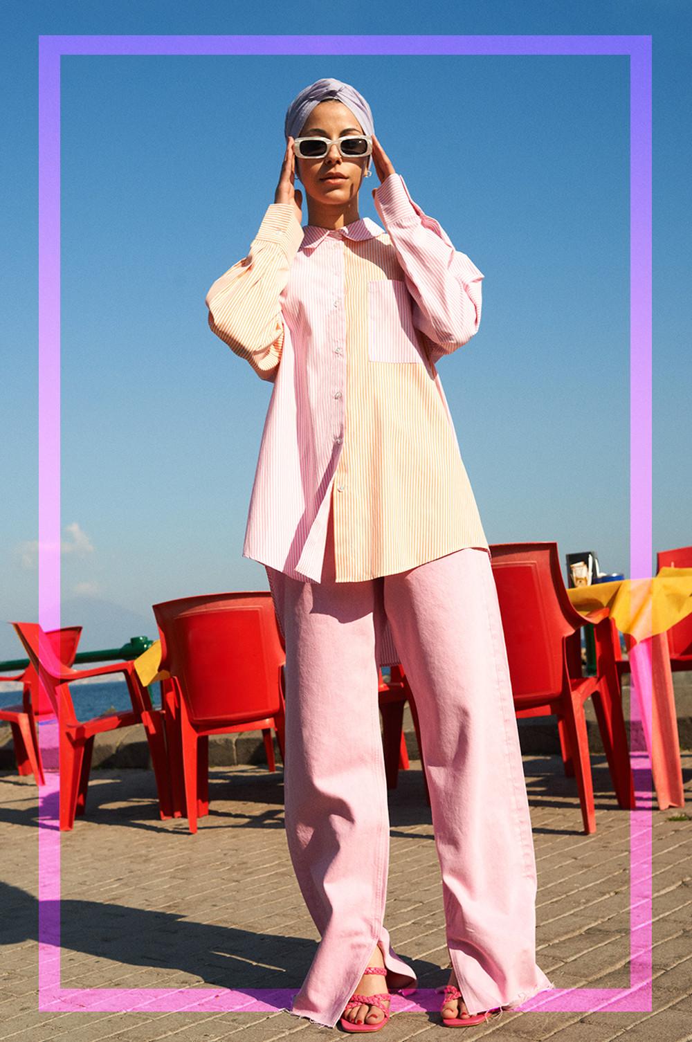 Woman wearing striped shirt, pink trousers and sunglasses