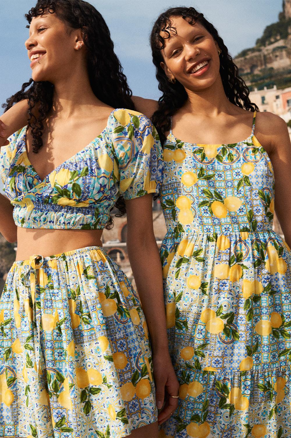 Models wear lemon print co-ord and printed midi dress