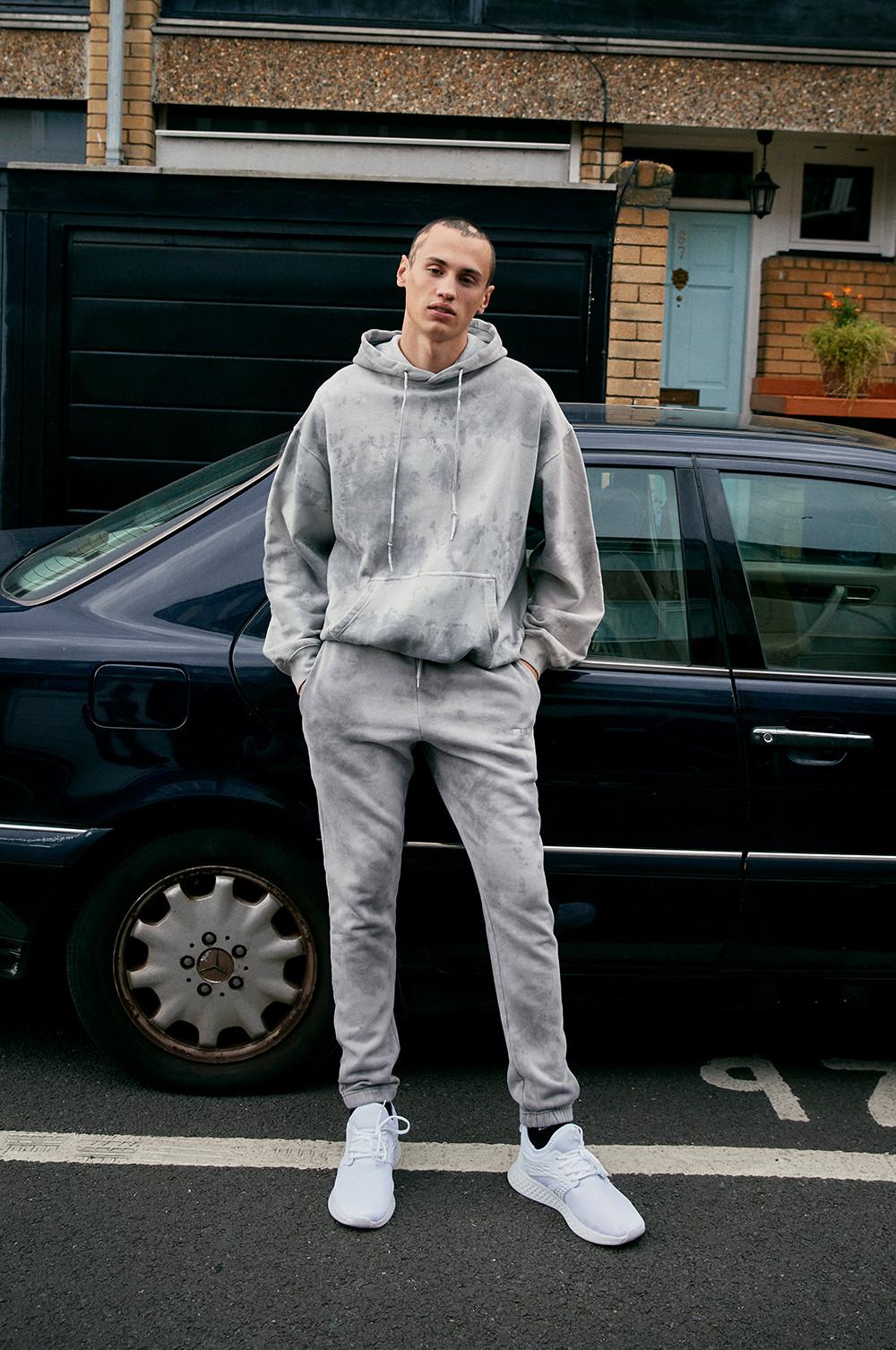 Mannequin portant un sweat à capuche et un pantalon de jogging gris clair à effet tie-dye