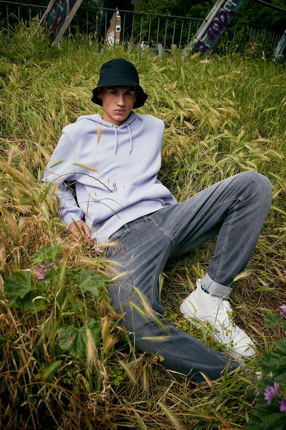 Mannequin portant un sweat à capuche gris clair et un jean gris