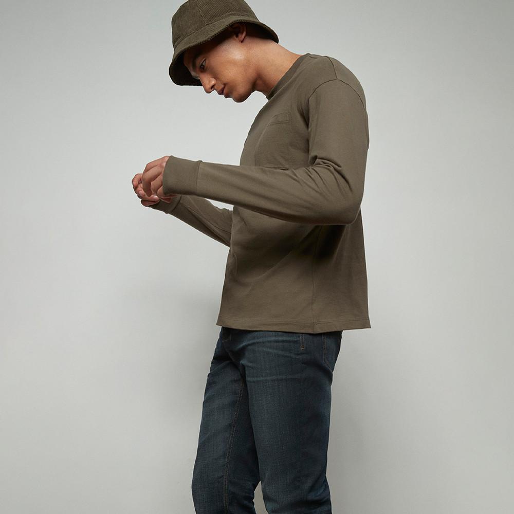 Model wears khaki tee and black jeans