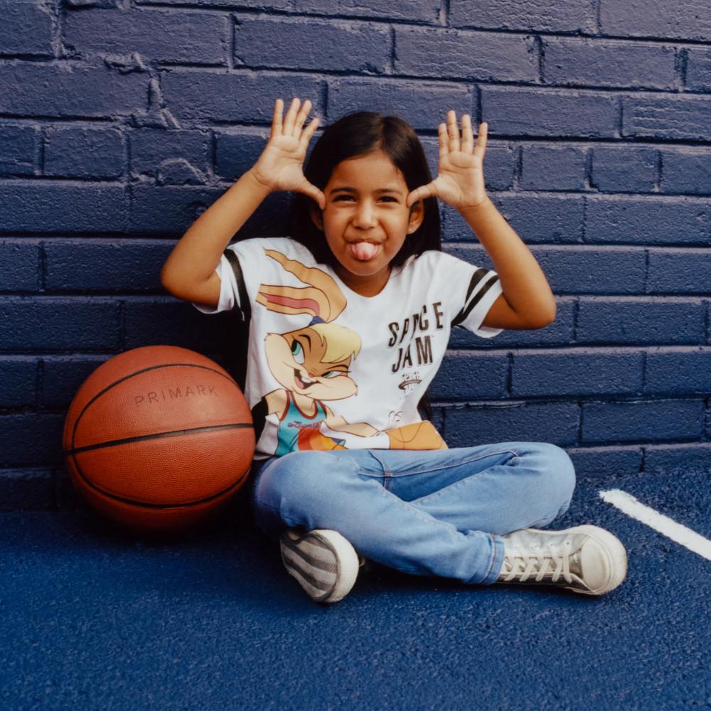 Model wearing Space Jam top and jeans with basketball