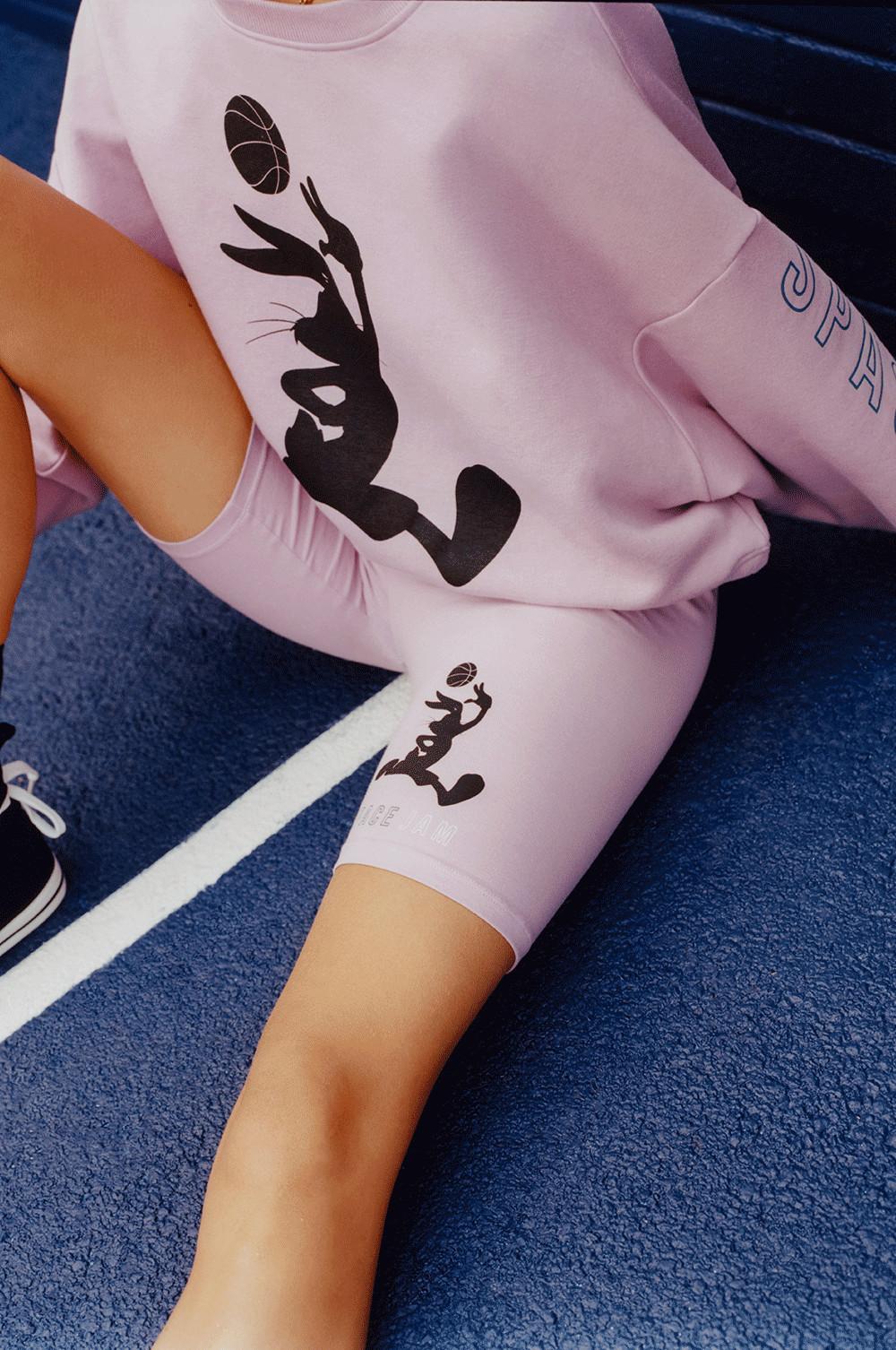 Model Wearing Pink Space Jam Sweatshirt and Cycling Shorts