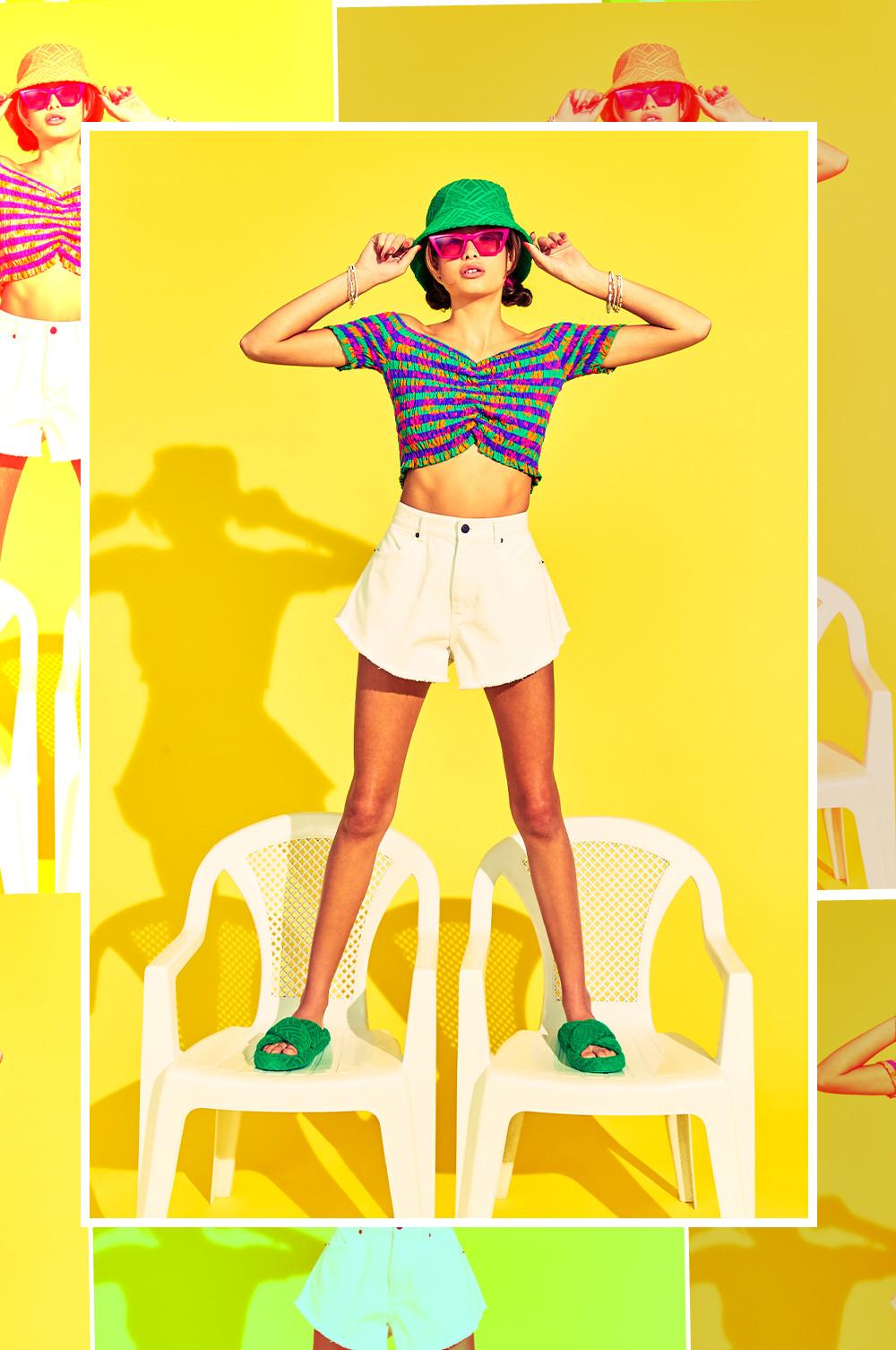 Model wears white shorts and bardot top, with matching bucket hat and sliders