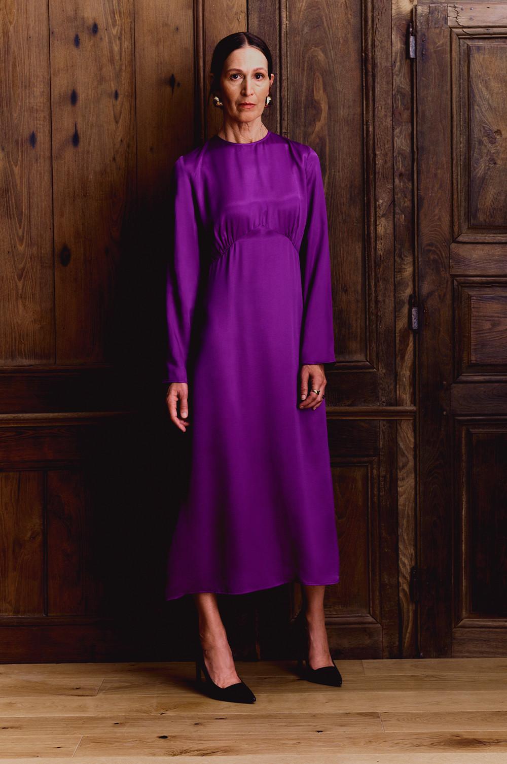 model wears purple satin dress