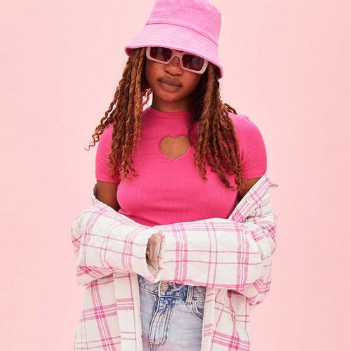 Model trägt pinkes Top mit Cut-out, Hemdjacke und Fischerhut