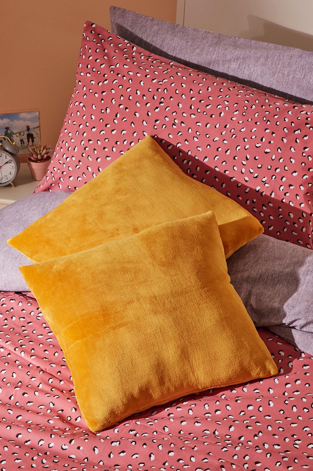 Cojines color mostaza en una cama