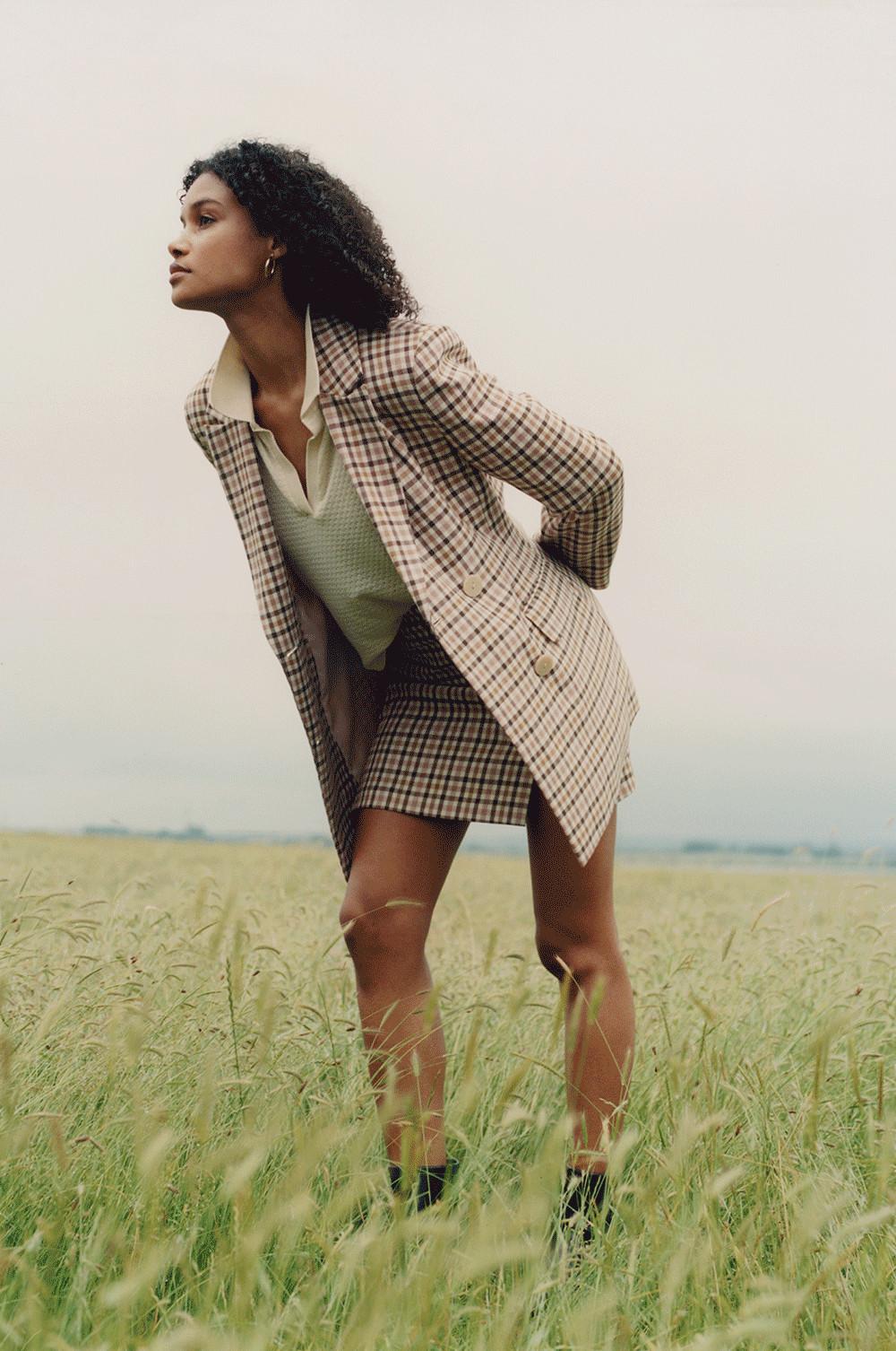 Model wearing beige shacket, pink mini skirt and cardigan