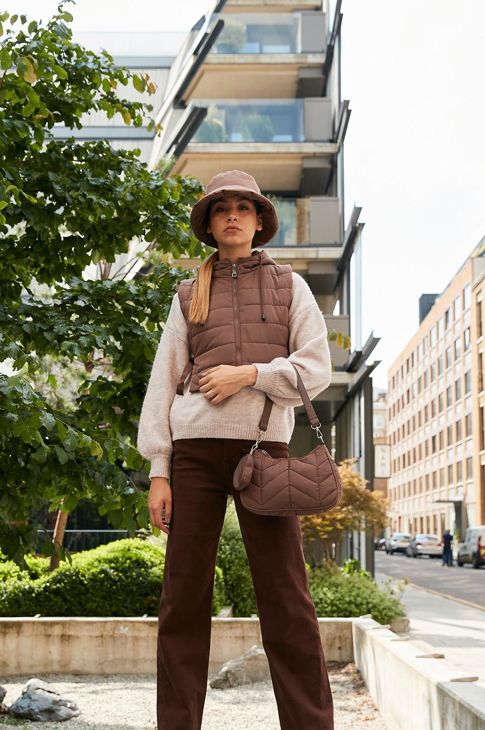 Model wearing hat and quilted outerwear