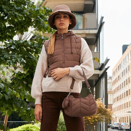 Model wearing hat and quilted outerwear