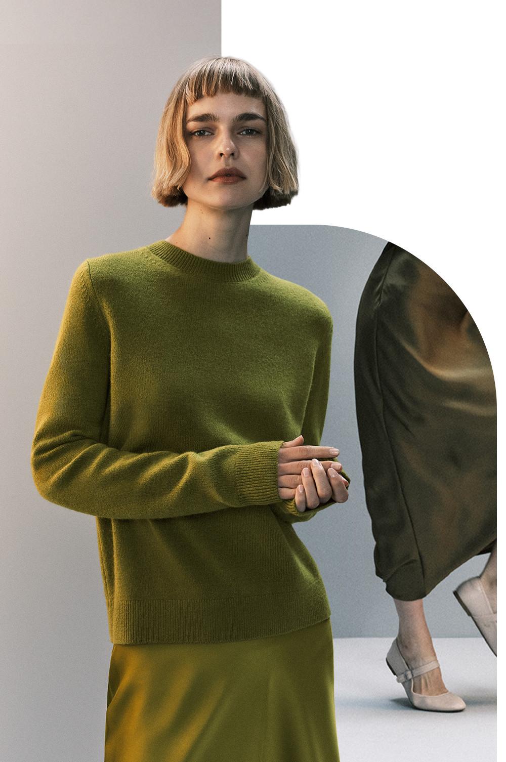 Person wearing an olive green knitted jumper and matching skirt with a short bob hairstyle.