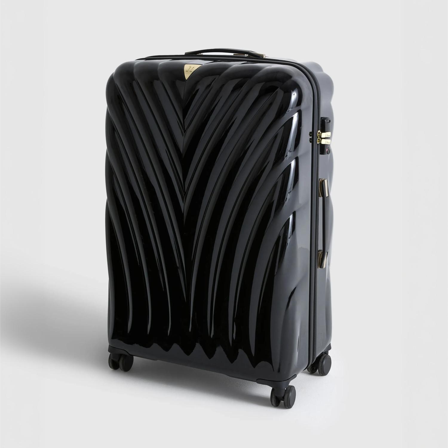 Black glossy hard-shell suitcase with distinctive V-shaped ridges and wheels, featuring gold accents.