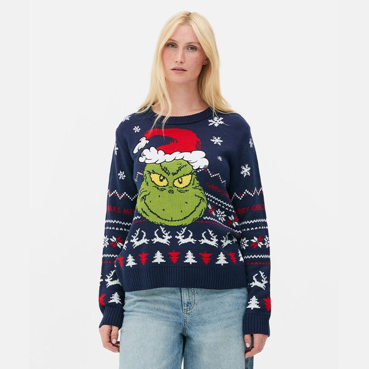 Navy Christmas jumper featuring the Grinch wearing a Santa hat with festive patterns of snowflakes, trees and reindeer.