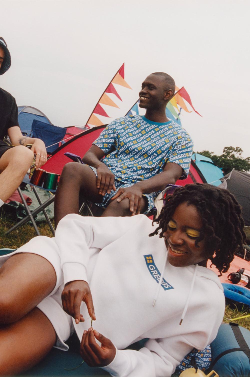 Model wears cropped white Greggs hoodie and shorts set