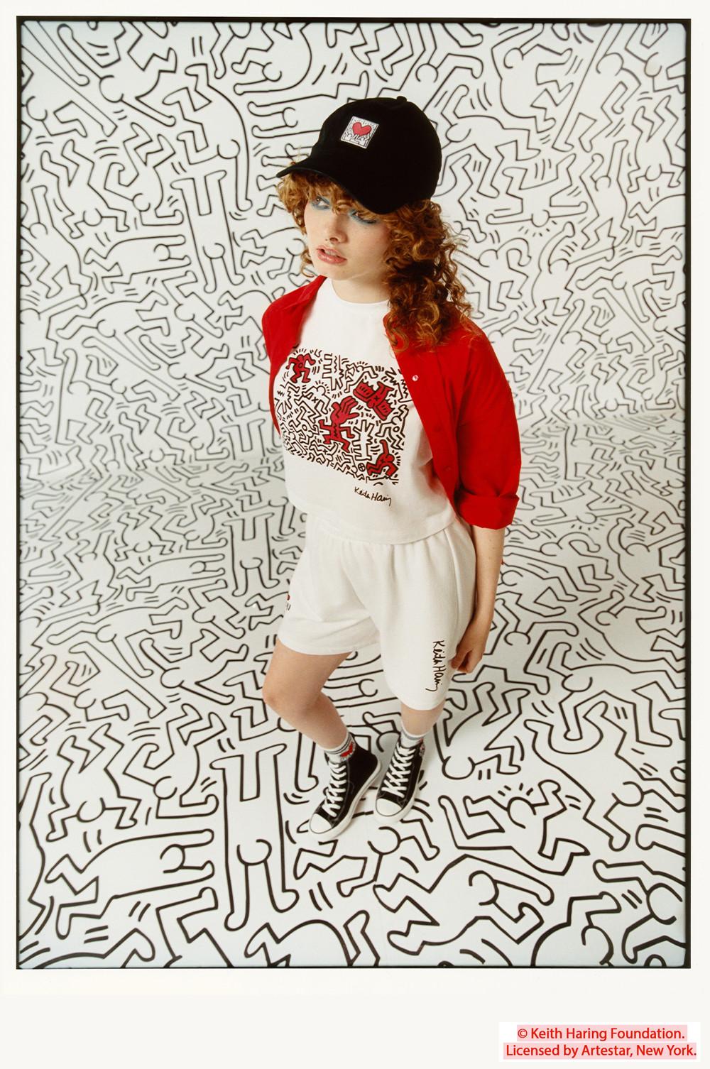 Modella che indossa T-shirt, pantaloncini e berretto nero Keith Haring