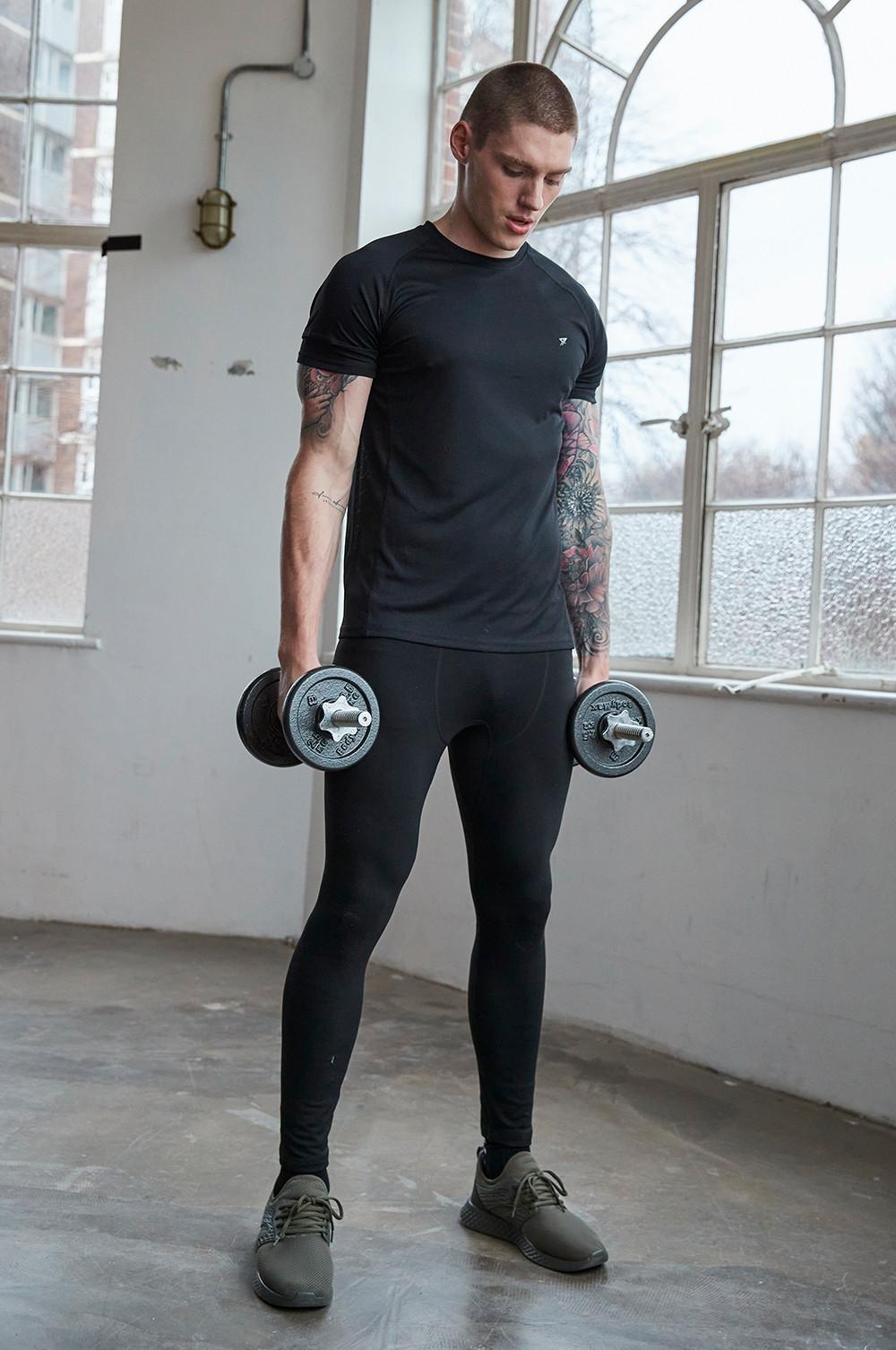 Hombre Cansado Con Botellas Y Toallas En El Gimnasio Foto de