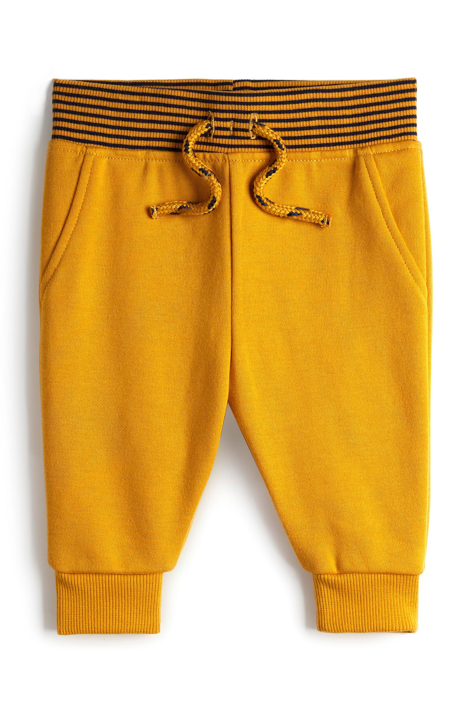 Pantalón de chándal color mostaza con cinturilla a rayas para bebé niño