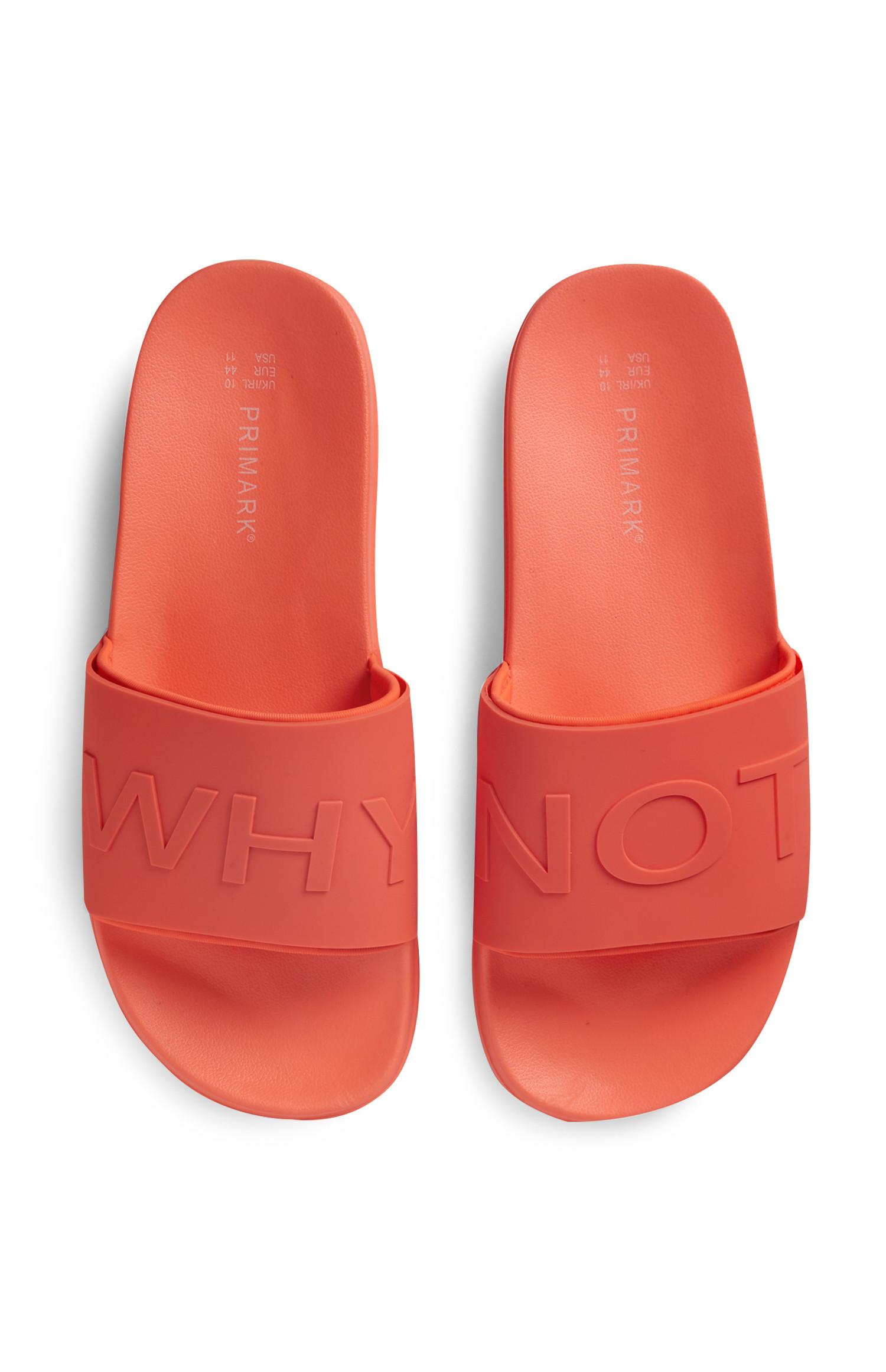 Korallenrote Badesandalen mit „Why Not“-Slogan